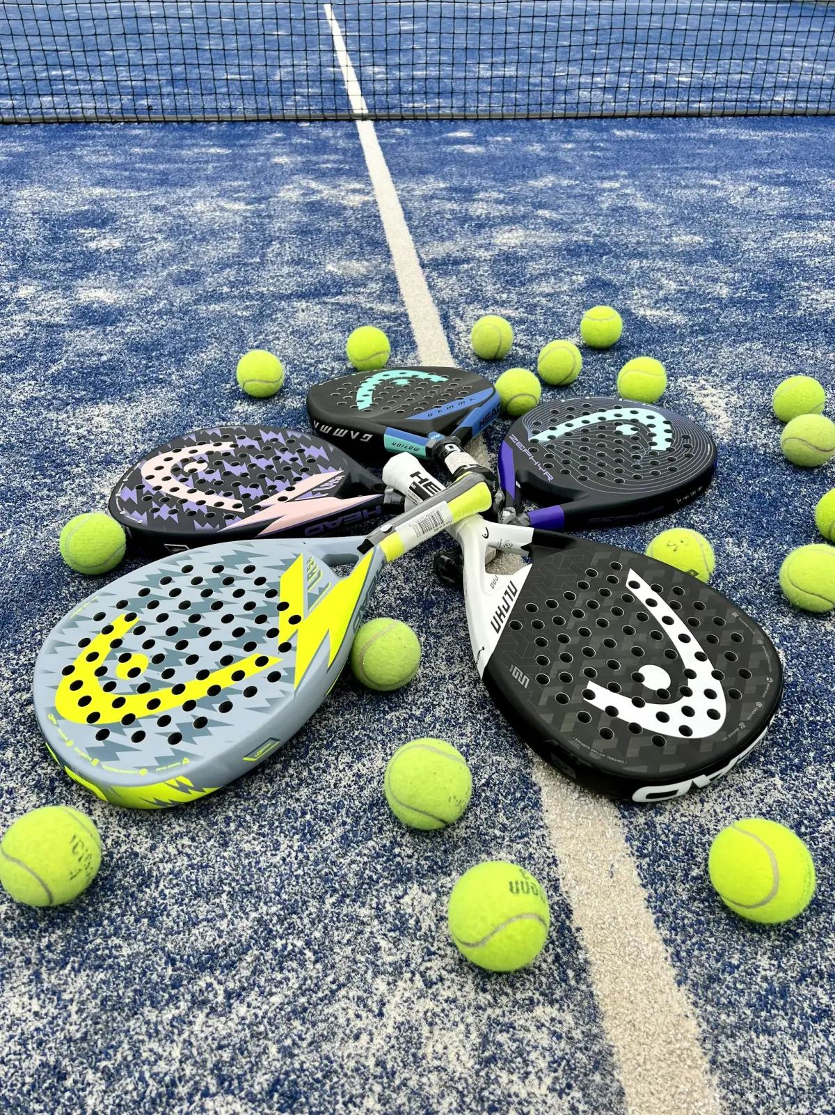 Head padel rackets and balls on a blue padel court